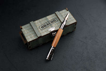 luxury gift pen. A set of expensive military pens in wooden boxes, compositions on a dark background...