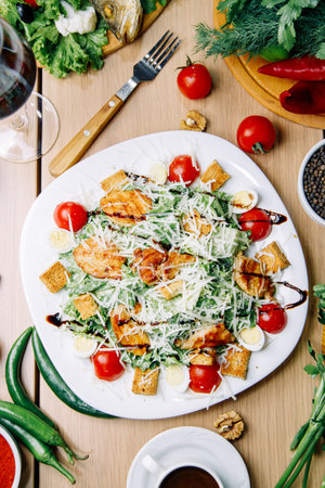 Restaurant serving dishes on a plate. Healthy Caesar salad of chicken with tomatoes and croutons.の写真素材