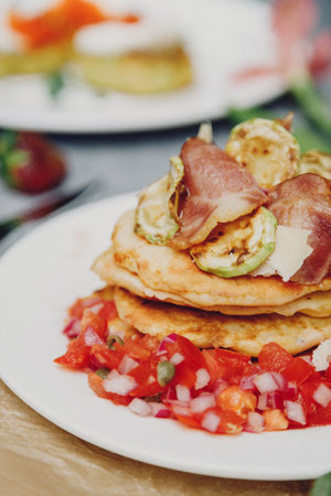 A stack of delicious pancakes with bacon, honey, nuts and caramelized banana. A hearty breakfast.の写真素材