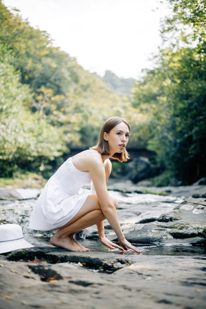 A tranquil moment presents a woman gracefully engaging with a calm and soothing water scene, embodying peaceの写真素材
