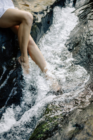 Bare feet splash in a gentle stream, beautifully embodying relaxation and the tranquility of natureの写真素材