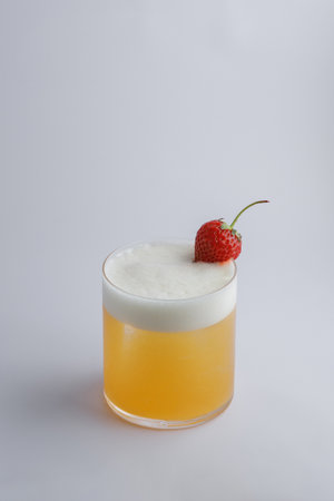 A refreshing drink that features a vibrant strawberry placed delicately on top, adding a delightful touch to its presentationの写真素材