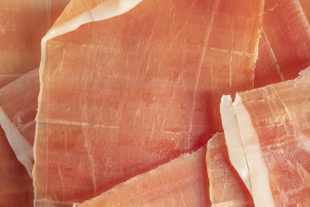 Dry Spanish ham, jamon serrano, bellot, Italian ham prosciutto crudo or parma, chopped layers, close-up, macroの写真素材