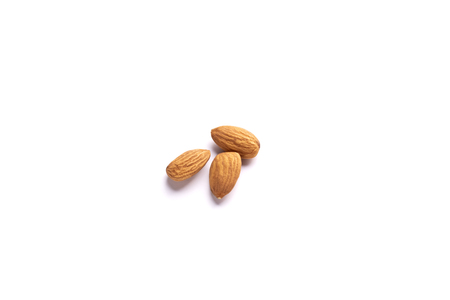 A pile of almond nuts macro view, isolated on white background.の写真素材