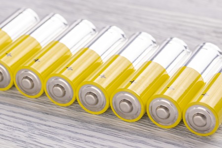 AA batteries lie on an old white wooden table. Reserve concept for future useの写真素材