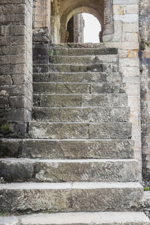 Entrance concrete staircase of an ancient Spanish church with dilapidated columns and arches