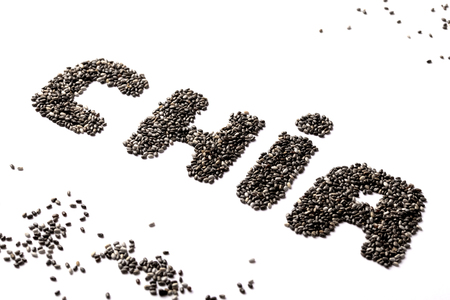 Chia seeds in the shape of the cropped word CIA. Isolate on white background. Scattered seeds around the inscriptionの写真素材