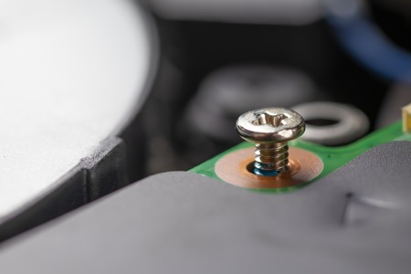 A shiny metal bolt securing the processor board, unscrewed in half. Disassembly and repair of...