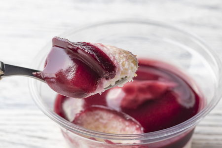 Tiramisu with the addition of blueberries in a plastic jar. Broke a piece of dessert spoon. Close-upの写真素材