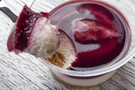 Tiramisu with the addition of blueberries in a plastic jar. Broke a piece of dessert spoon. Close-upの写真素材