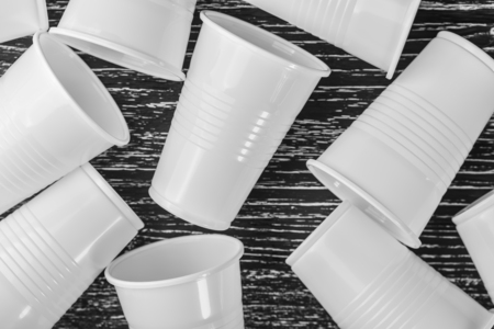 A group of white plastic cups scattered on a black table. Macro closeup photoの写真素材