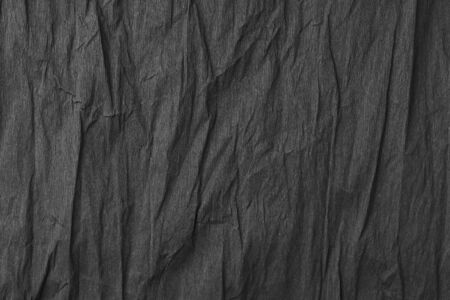 Black textured creased wrapping paper. Excellent background for design and lettering.の写真素材