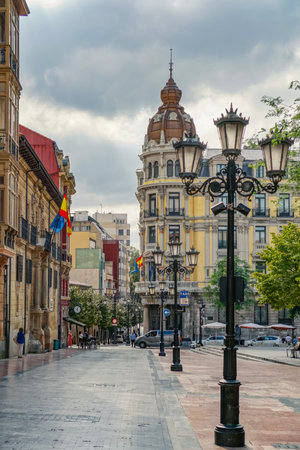 Oviedo, Spain - 07.09.2019 EDITORIAL: Street with lanterns and ancient buildings. Local historic buildings People walkingのeditorial素材