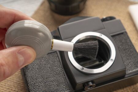 Hand brushes with a blower a camera matrix on a sack and a wooden table. wipes are nearbyの写真素材