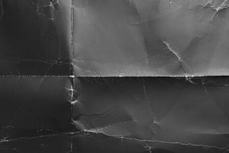 Wrinkled black old paper with frayed wrinkles and a contrasting texture. Dusty cardboard wrapping....
