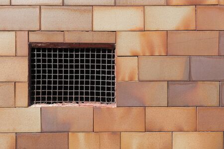 Old basement window with a rusty old prison iron grate with cobwebs on a brickwork wall. Copyspace. Concept of imprisonmentの写真素材