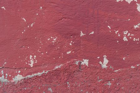 Old concrete red painted wall with unevenness and drips. Abstract background