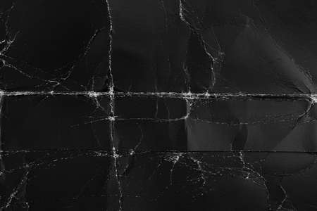Black old paper with folds and roughness. Abstract dramatic background. For design and titles.の写真素材