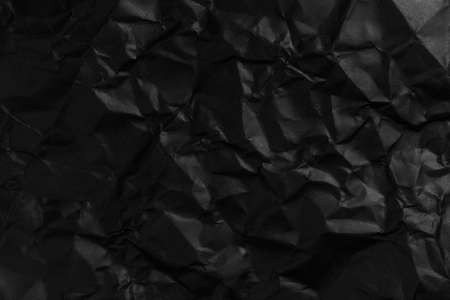 Blank crumpled and straightened black paper with wrinkles for design dark backgroundの写真素材