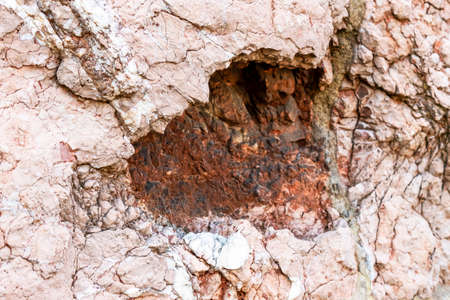 Damage from the fall of an artillery shell on the antique wall of an ancient building close-upの写真素材
