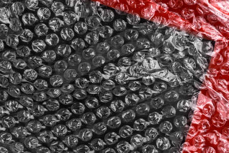 Abstract black red plastic background with wrap and adhesive tape. Diagonal view