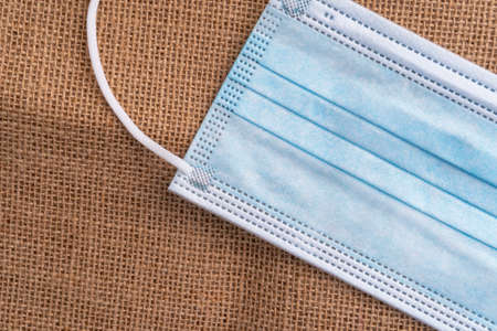 Medical protective mask on a rural rough sackcloth. Close up
