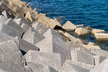 Stone cubes of a breakwater of a sea dam close upの写真素材