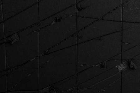 Black paper abstract background with scratches and creases. Torn grunge folded damaged cardboardの写真素材