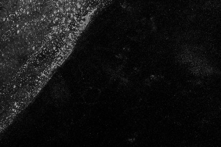 Black weathered rough grunge background. Dark mottled texture with dots. Copy spaceの写真素材