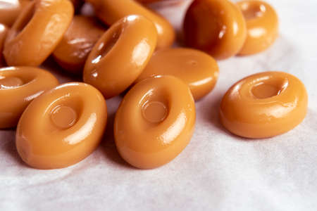 Sugar candies on a white napkin. Chocolate hard suckers close-up. Macro. Selective focus. Delicious creamy caramelの写真素材