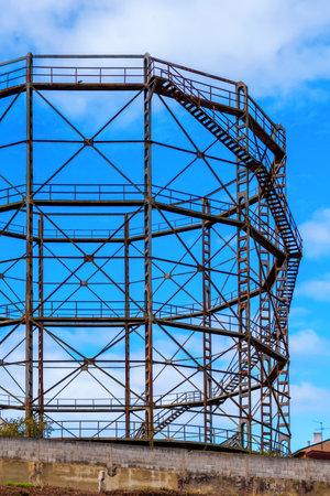 Cylindrical framework of industrial gas storage under construction with metal girders on a sky backgroundの写真素材