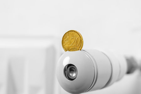 European coin on the thermostat of a hot central heating radiator. global energy crisis concept. Expensive gas price ideaの写真素材