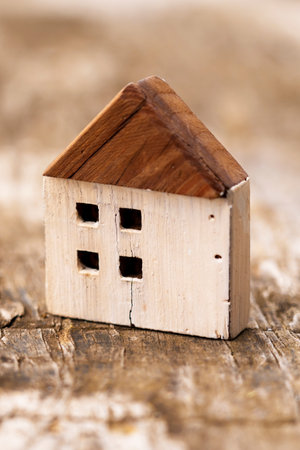 Cracked wooden house model on a grunge board. economic crisis idea. Bankruptcy and business failure...