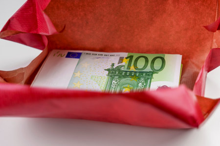Gift money wrapped in red paper. financial holiday present and bonusの写真素材