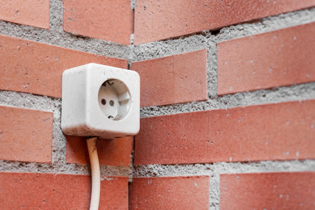 Balcony outdoor electrical outlet on a brick wall. Power source in the house close upの写真素材