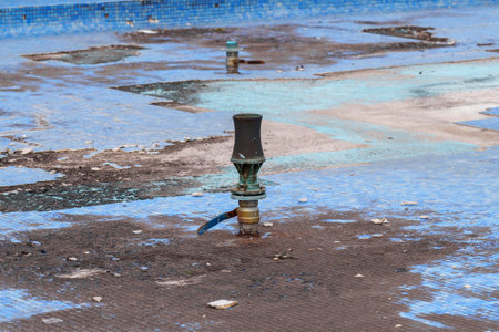 Nozzle of urban fountain with silt in a dirty basin for maintenance and cleaningの写真素材