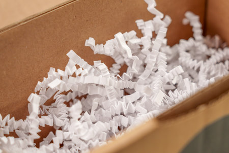 Open cardboard box with white shredded plastic filler close up