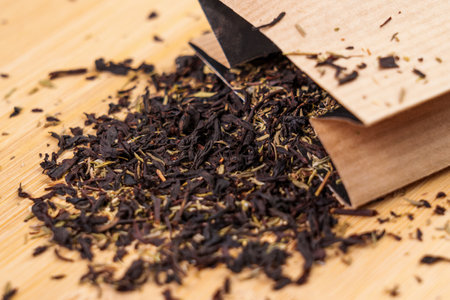 Scattered packaged black herbal tea with thyme with a paper pack close upの写真素材