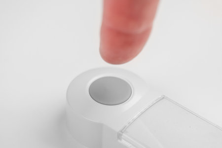 Patient hand pressing emergency nurse call button for help close up. Assistance concept