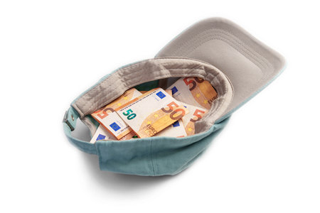 Alms baseball cap with euro banknotes. Money donation and poverty concept. Isolated on a whiteの写真素材