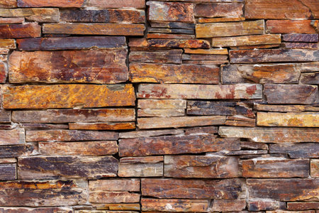 A wall made of brown stone blocks of the facade close up. Abstract natural backgroundの写真素材