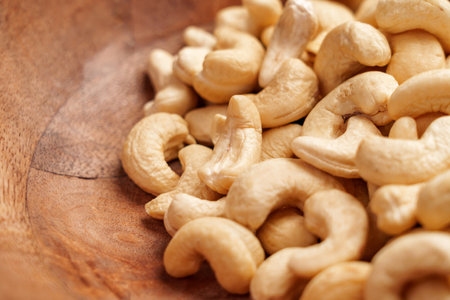 Fresh natural raw cashew nuts in wooden bowl closeupの写真素材