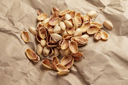 Separate waste collection concept. Organic biodegradable pistachio nushell on a recycled paper close...