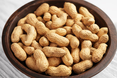 Peanuts pods in shell. Full rustic bowl of crunchy nutritious ingredient.
