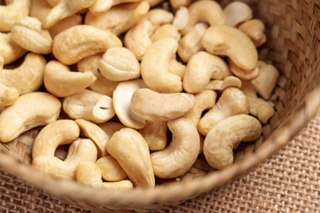 Raw peeled cashew nuts in rattan wicker ecological bowl. Organic healthy ingredientの写真素材