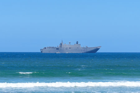 Gijon, Spain - May, 24, 2024: A large warship sails on the calm ocean waters under a clear blue skyのeditorial素材