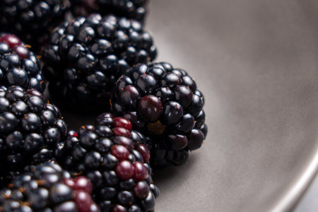 Black bramble berries in grey ceramic plate. Fresh juicy organic blackberries. Healthy ingredient....