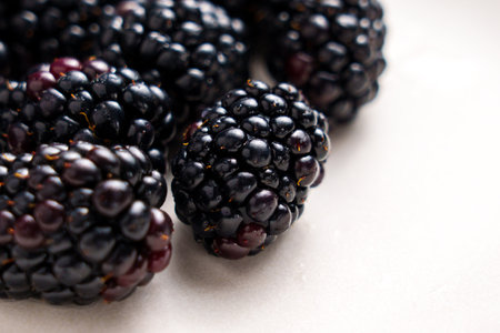Fresh ripe juicy blackberry on a white ceramic surface. Sweet healthy organic vitamin berries. Macro...