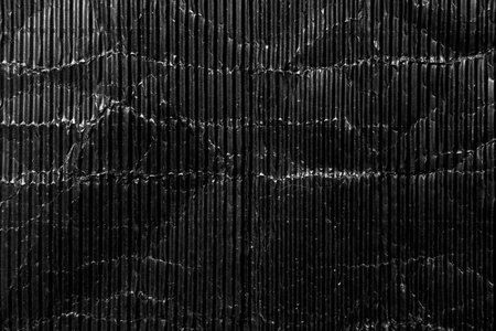 Crumpled corrugated black paper poster. Rough old grunge cardboard background