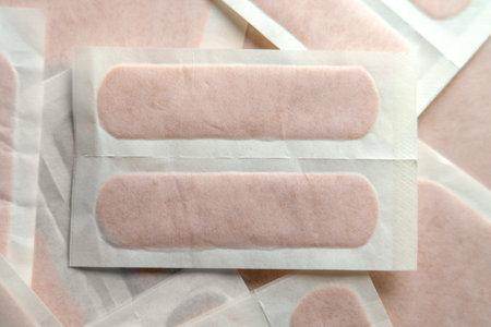 Close-up of sterile adhesive bandages in individual packaging for wound care and first aid. Soft light highlights their hygienic design. Top viewの写真素材